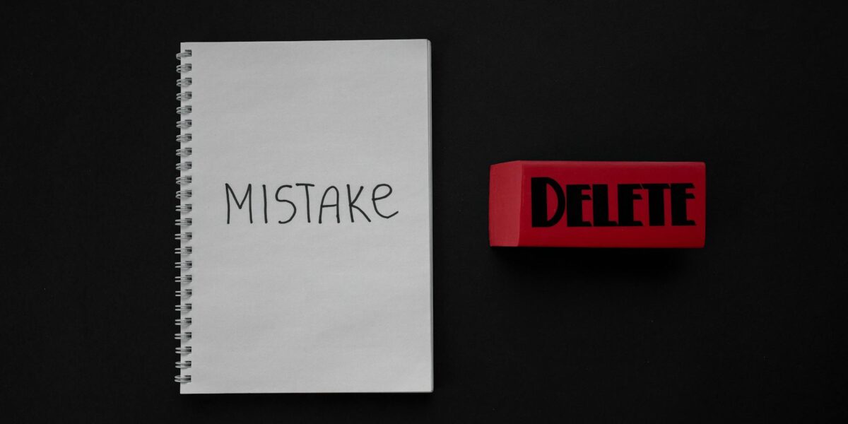 Notebook labeled 'Mistake' next to a red delete eraser on a dark background.