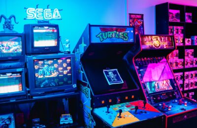 A vibrant retro arcade room featuring classic gaming machines and colorful neon lighting.