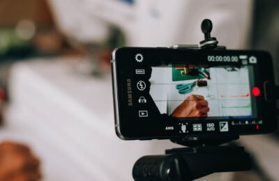 Smartphone on tripod capturing person writing on paper, showing content creation process.