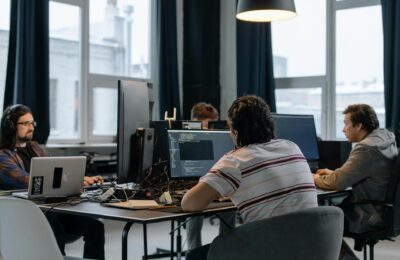 Team of developers working together on computers in a modern tech office.