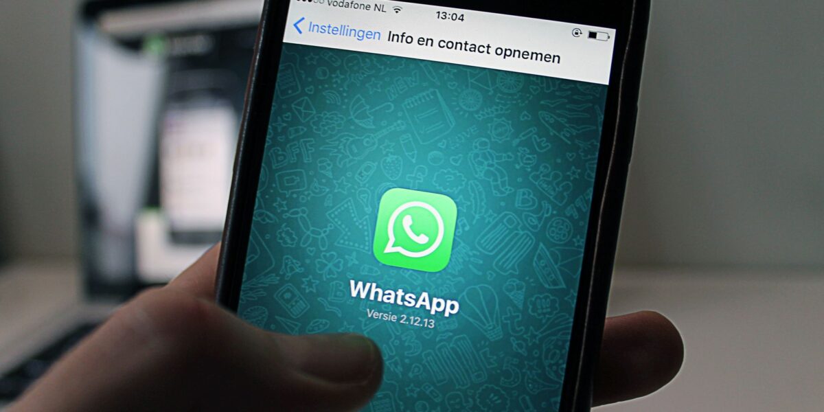 A smartphone displaying the WhatsApp application screen held by a person.