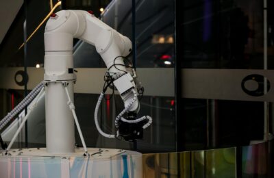 A white robotic arm operating indoors with a modern design and advanced technology.