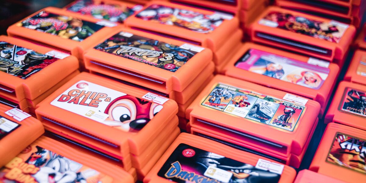 Close-up of stacked retro video game cartridges in orange cases, showcasing popular titles.