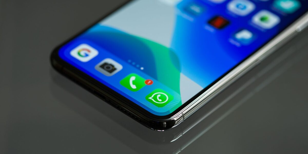 Close-up shot of a smartphone screen displaying various app icons including WhatsApp.