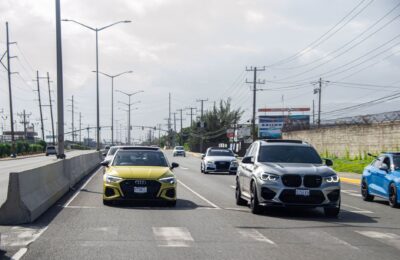 A variety of cars on a busy highway in Jamaica, showcasing urban travel.