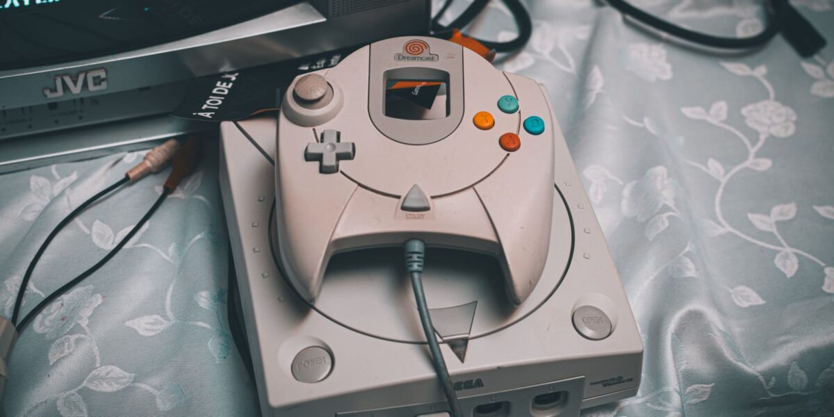 Close-up of a Sega Dreamcast console with controller and CRT monitor in a retro gaming setup.