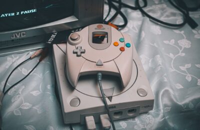 Close-up of a Sega Dreamcast console with controller and CRT monitor in a retro gaming setup.