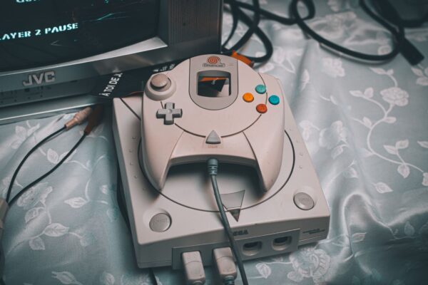 Close-up of a Sega Dreamcast console with controller and CRT monitor in a retro gaming setup.