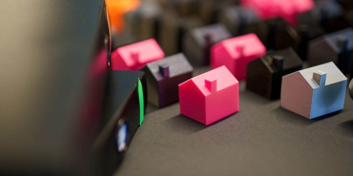 Vibrant miniature houses on a dark surface, illustrating real estate investment and property concepts.
