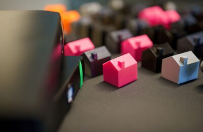 Vibrant miniature houses on a dark surface, illustrating real estate investment and property concepts.