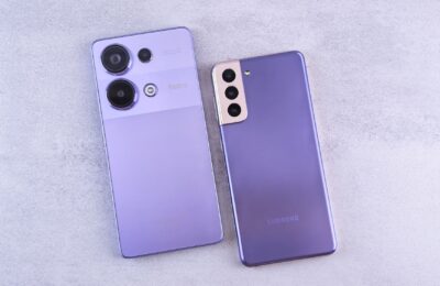 Detailed image showcasing two purple smartphones on a light surface.