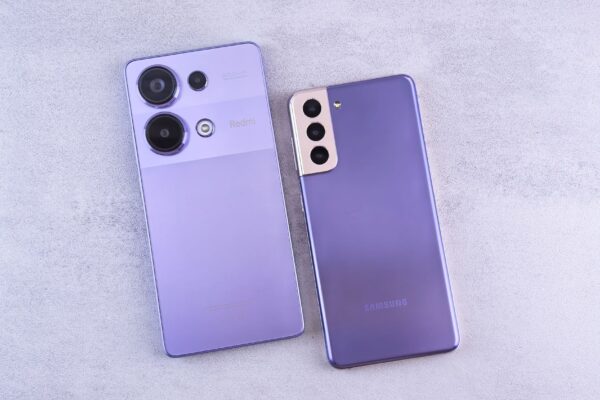 Detailed image showcasing two purple smartphones on a light surface.