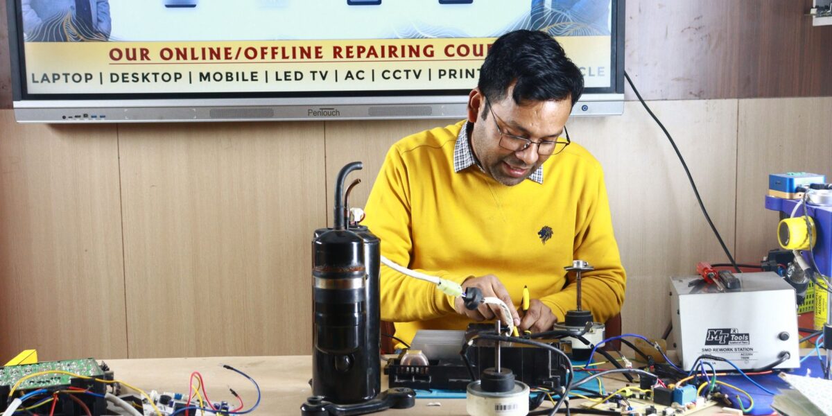 Technician engaged in AC repair at a New Delhi workshop. Indoor learning session.