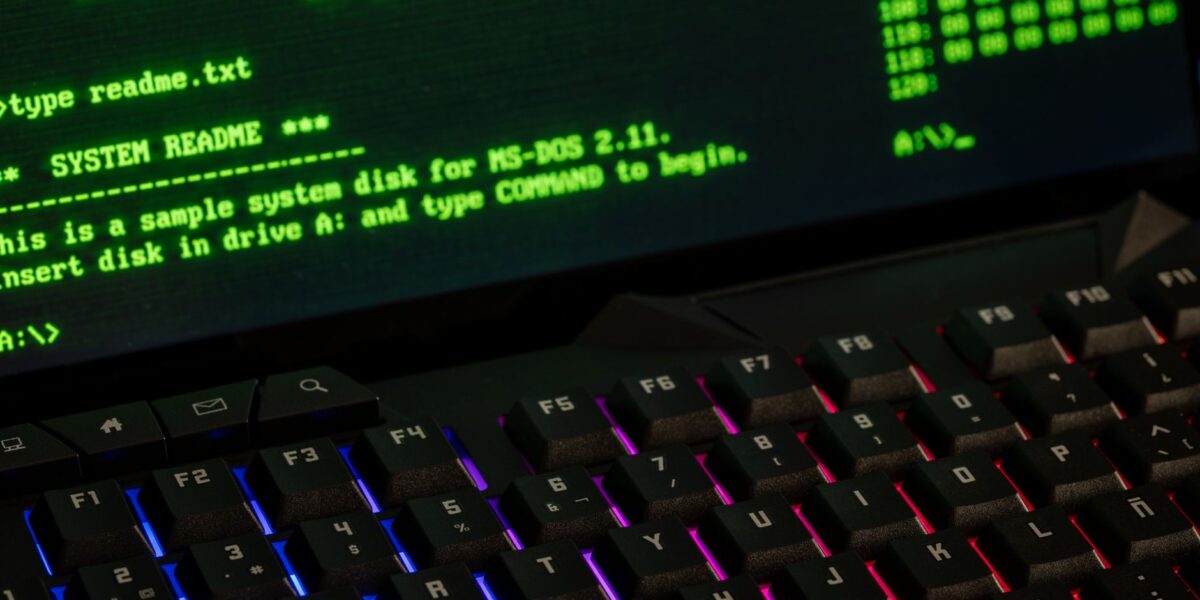Close-up of a retro computer screen displaying MS-DOS commands with a vibrant keyboard.