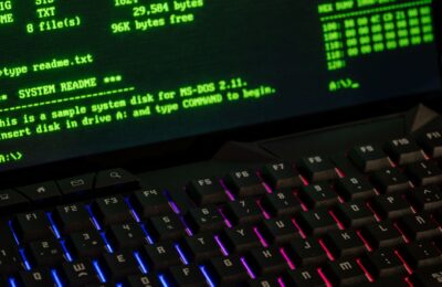 Close-up of a retro computer screen displaying MS-DOS commands with a vibrant keyboard.