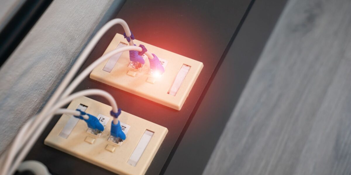 Close-up view of Ethernet ports with cables and illuminated LED indicator. Modern data connection setup.