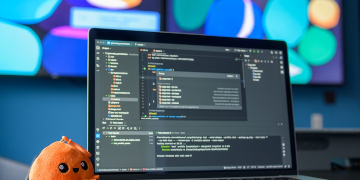 Colorful workspace featuring a laptop with code editor and vibrant screens.