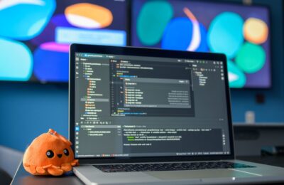 Colorful workspace featuring a laptop with code editor and vibrant screens.