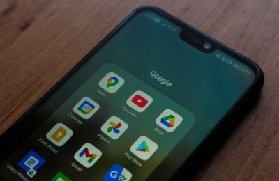 Close-up of a smartphone showing various Google apps on its screen.