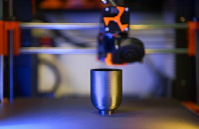 Innovative close-up of 3D printer crafting a metallic object, showcasing modern technology.