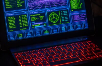 Futuristic digital interface displayed on laptop screen with neon red keyboard.