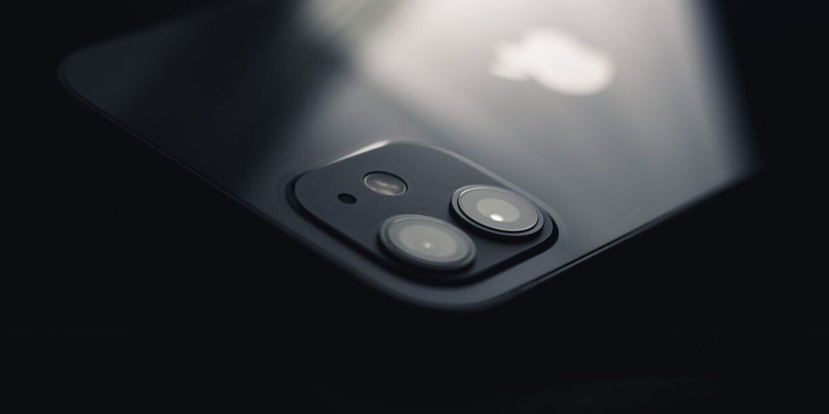 Close-up shot of a smartphone camera lens reflecting light, highlighting modern technology.