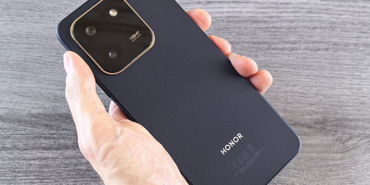 Detailed shot of a person holding a sleek smartphone with a visible camera module.
