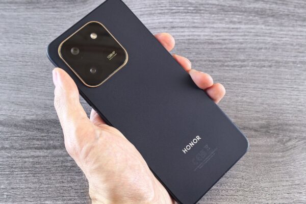 Detailed shot of a person holding a sleek smartphone with a visible camera module.