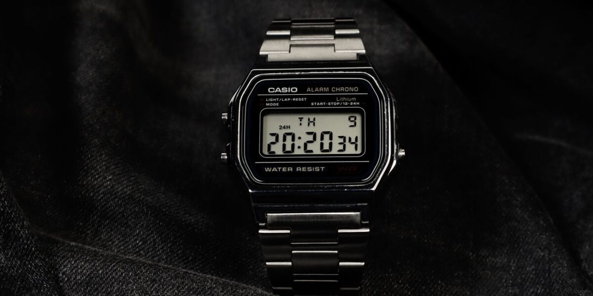 Digital wristwatch displayed elegantly on dark fabric, highlighting its modern design.