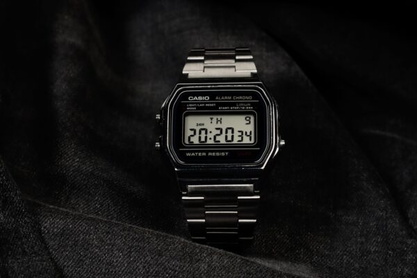 Digital wristwatch displayed elegantly on dark fabric, highlighting its modern design.
