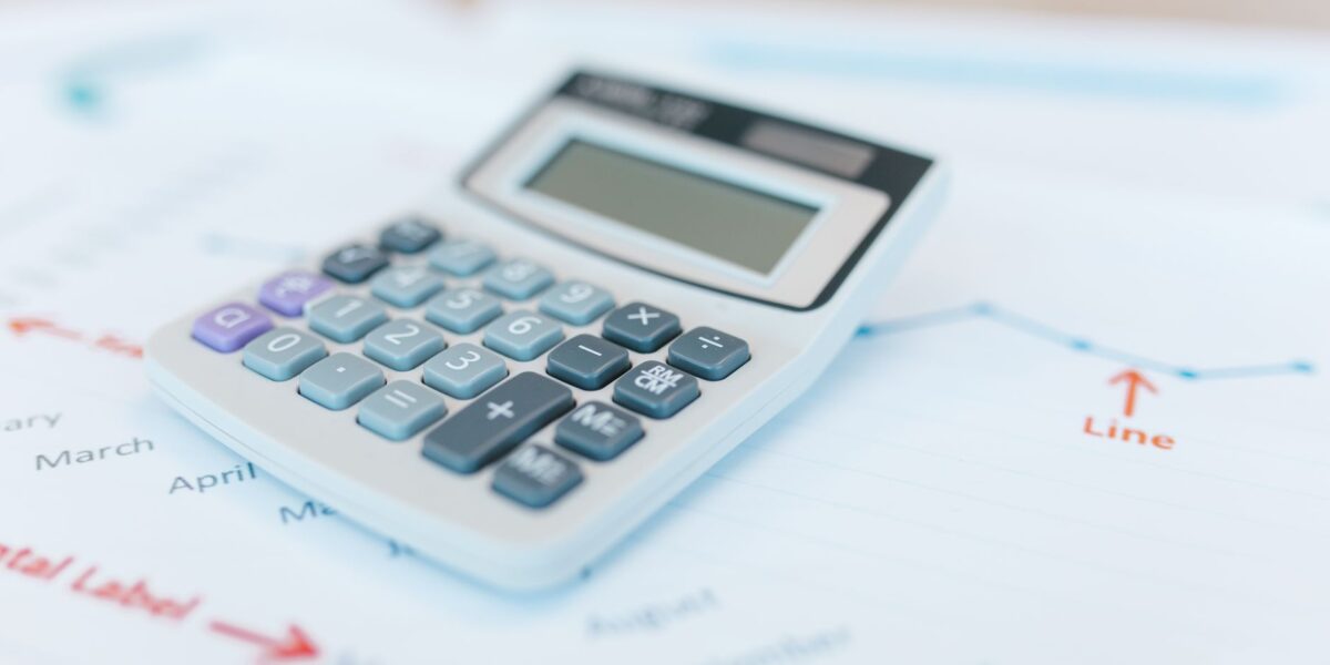 Close-up of a calculator on financial documents with graphs and analysis papers.