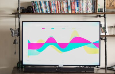 Modern living room with TV showing a vibrant, colorful graph and a shelf full of DVDs.