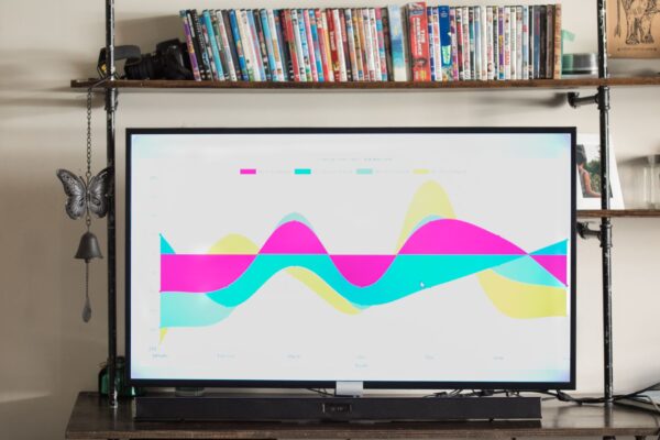 Modern living room with TV showing a vibrant, colorful graph and a shelf full of DVDs.