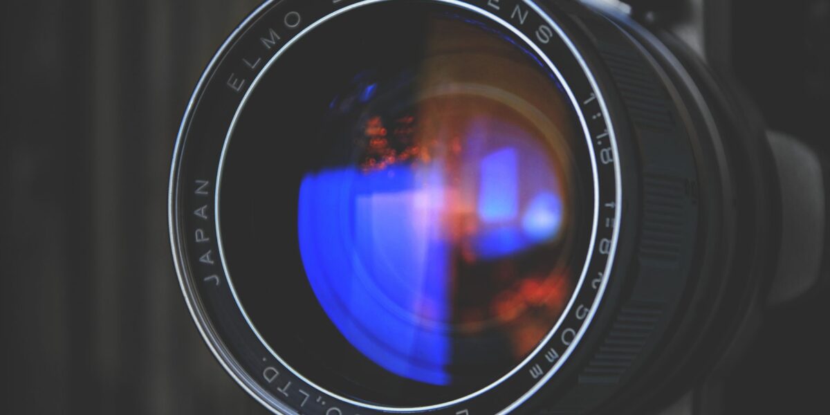 Detailed close-up of an Elmo zoom camera lens capturing vivid reflections. Perfect for photography enthusiasts.