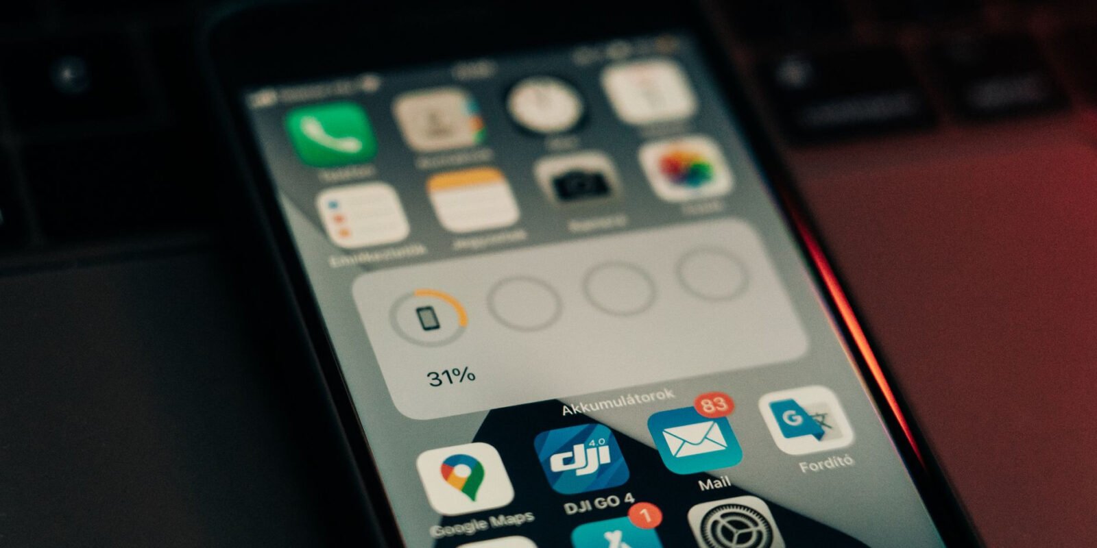A smartphone with various apps on its screen placed on a keyboard, showing a 31% battery level.